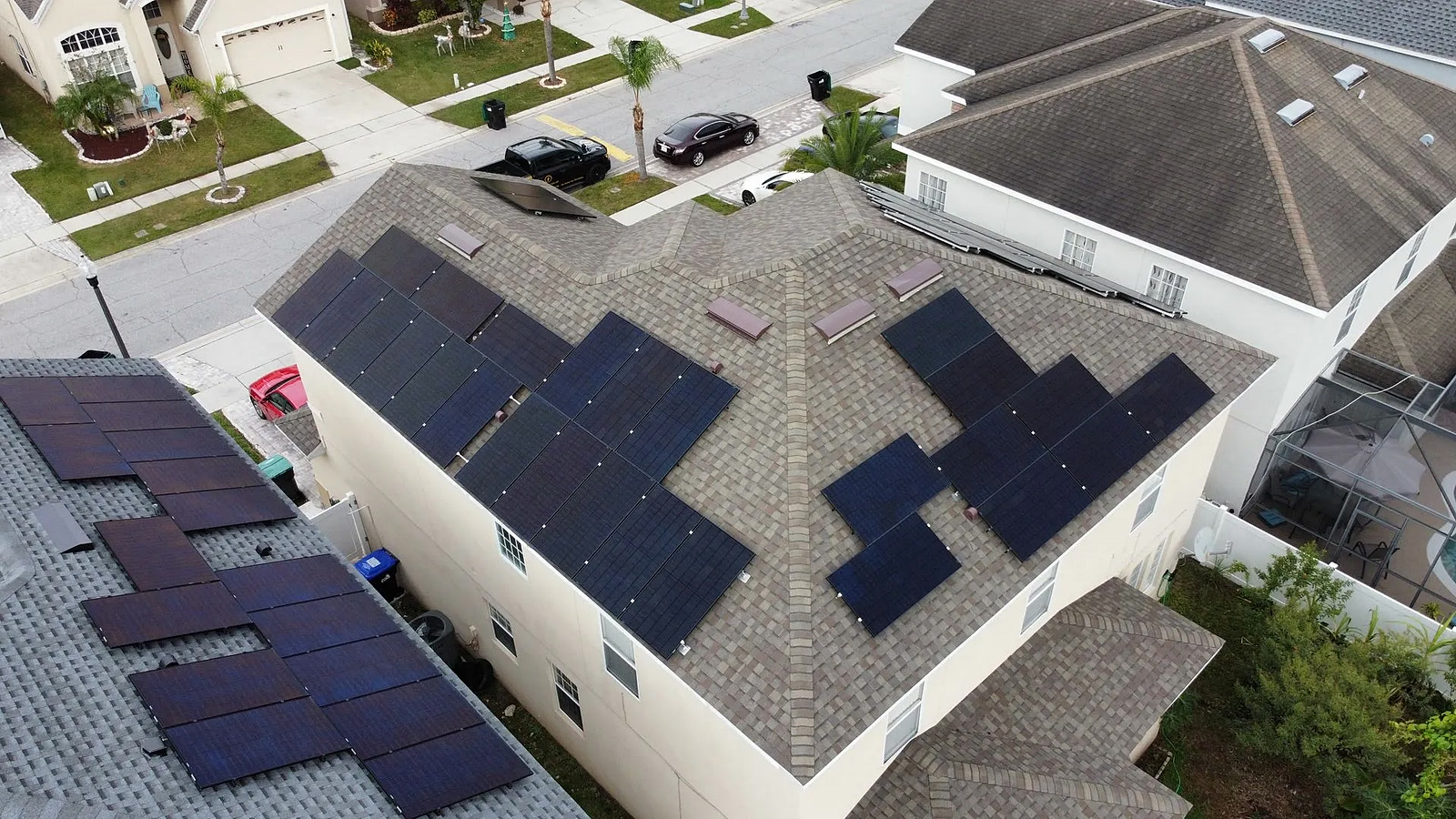 Aerial view of a zigzag-pattern solar array on a shingle roof